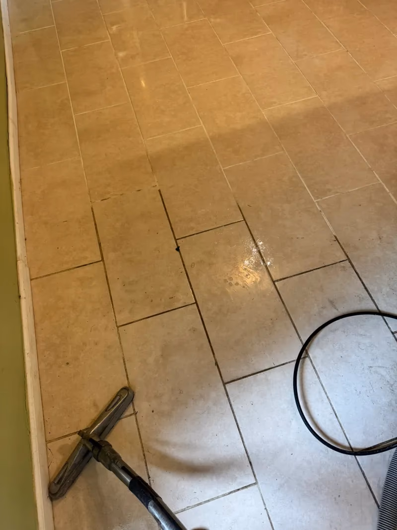 Before and after tile and grout cleaning showing gray and beige square tile, grout lines, and a decorative mosaic border — Lehigh Valley, PA