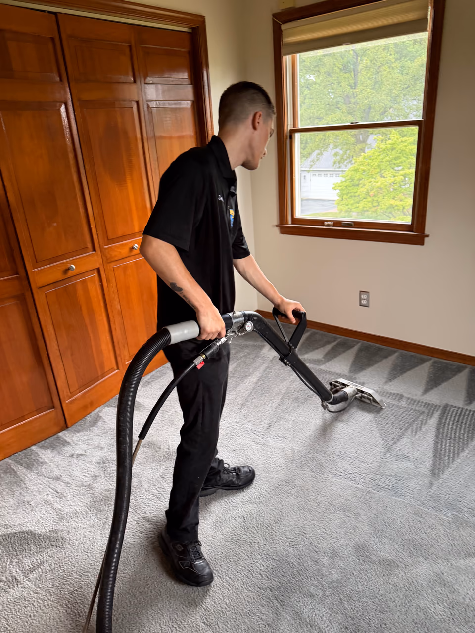 Carpet cleaning technician using extraction wand on residential carpet — local job in the Lehigh Valley